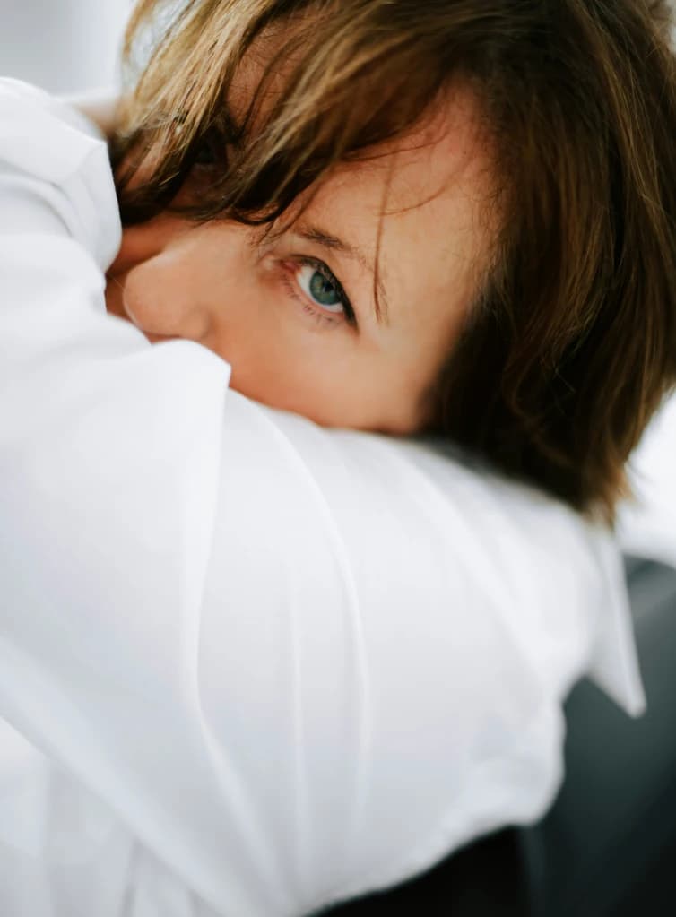 Vrouw die in de leeftijd kan zijn dat ze in de overgang zou kunnen zitten kijk droevig in de camera