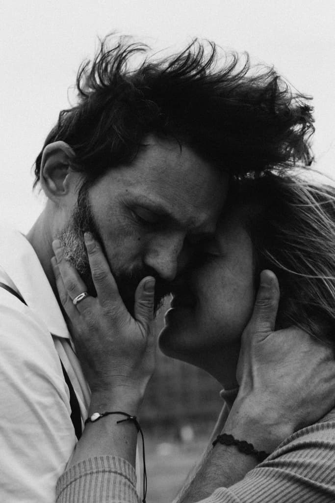 Zwart-wit foto van stel dat elkaars hoofd vasthoudt - uitbeelding van genegenheid en liefde